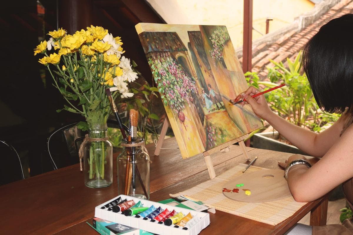A guest painting a canvas at the studio