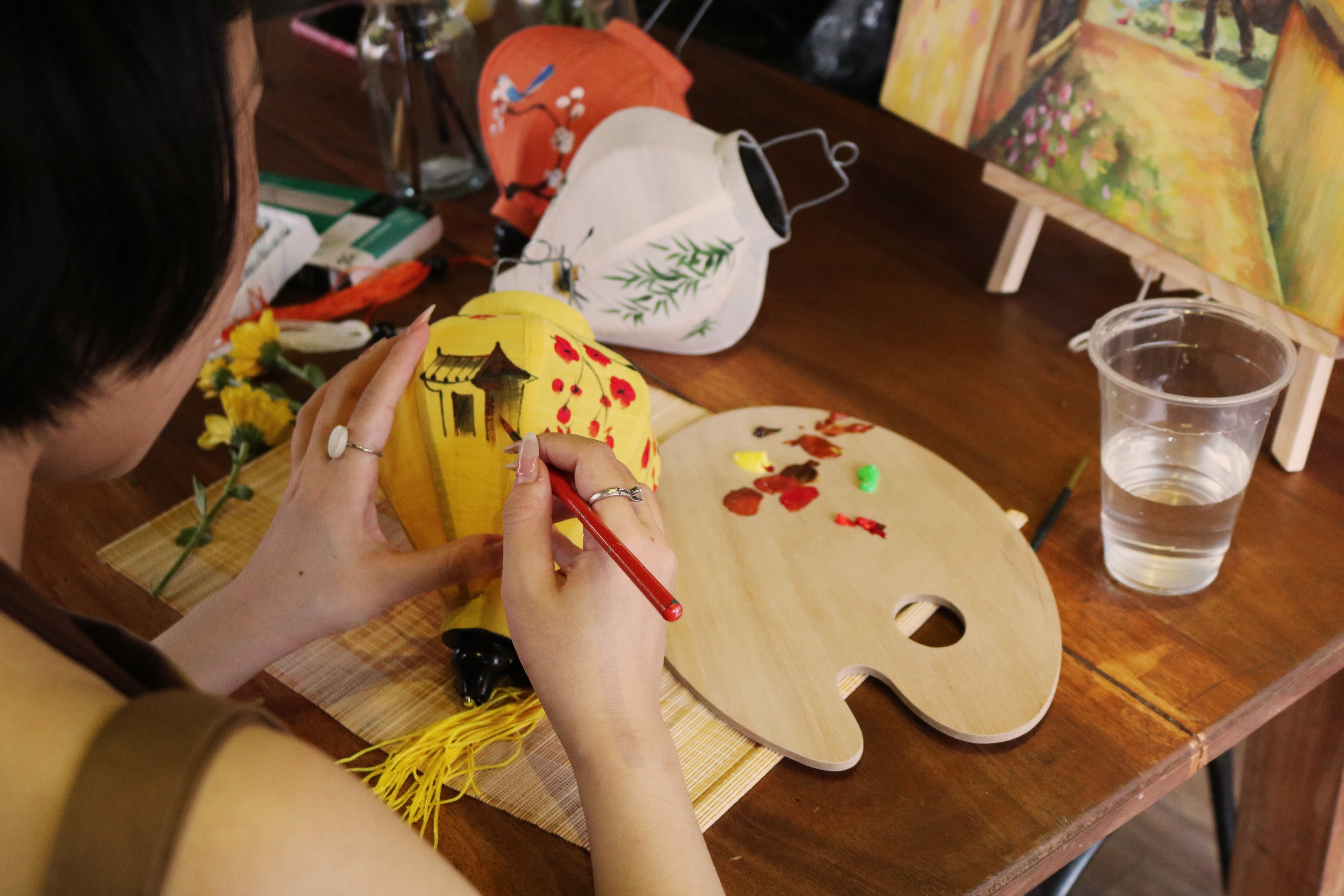 Two guests painting lanterns side by side